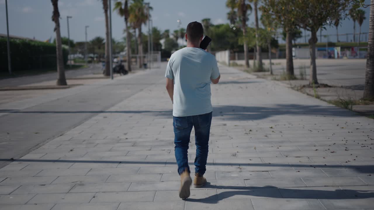 Man walking on a city street with a tablet