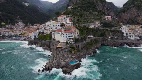 swimming pool by ocean cliffs on amalfi coast, amalfi, italy - aerial