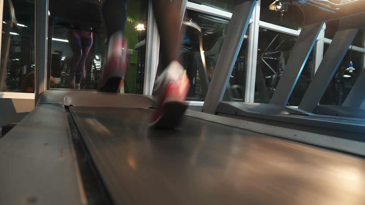 Female muscular feet in sneakers running on the treadmill at the gym. Concept for fitness, exercising and healthy lifestyle.