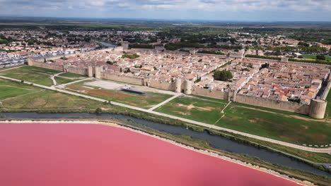 drone shot of a old town in france with pink ocean in front of it