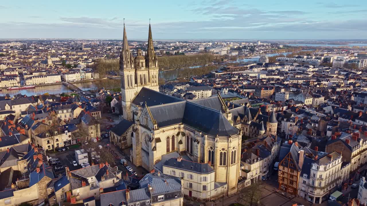 Orbita di drone intorno alla Cattedrale di Saint-Maurice che rivela la facciata posteriore, la città storica di Angers e il fiume Maine nella Valle della Loira all'alba. Francia