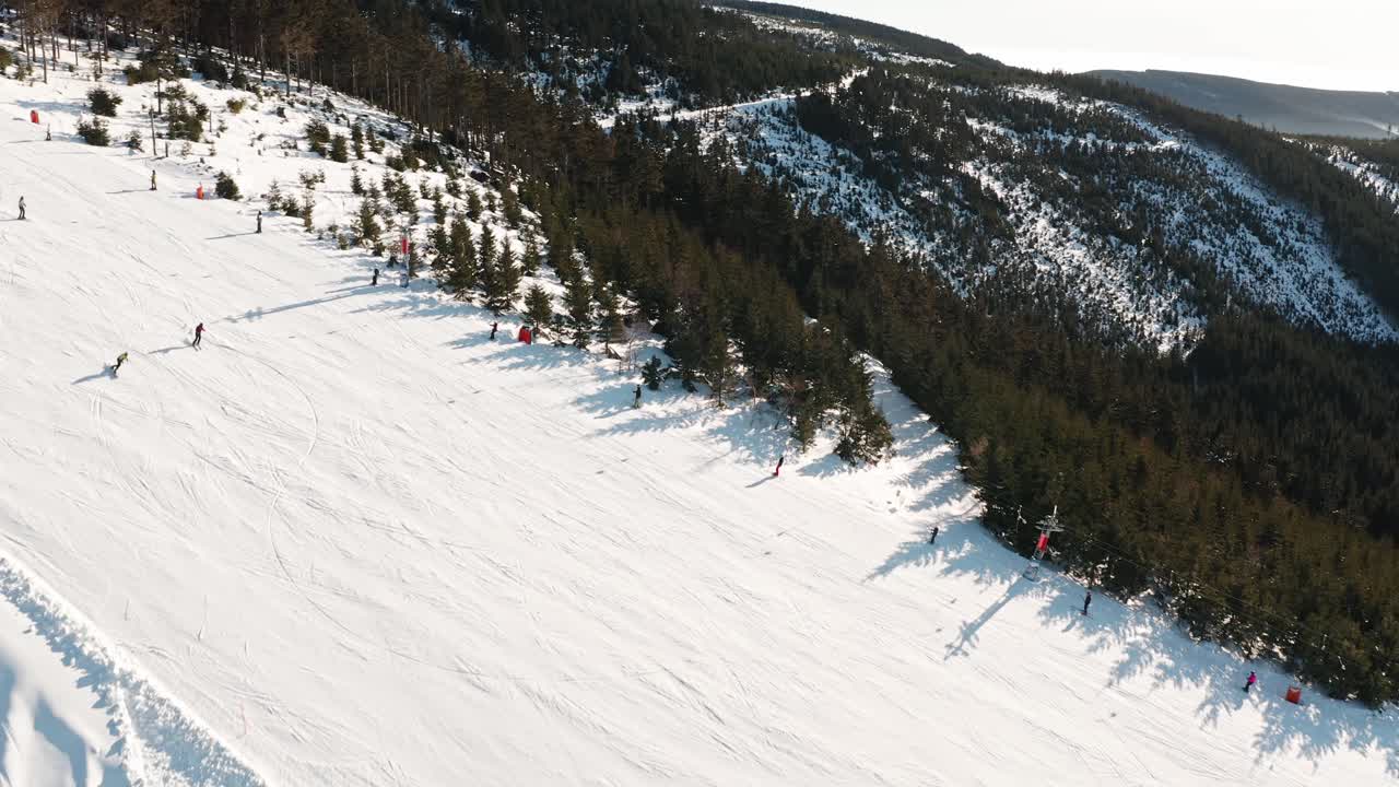 Pista da sci alpino con sciatori in un resort montano della Repubblica Ceca, ripresa da drone
