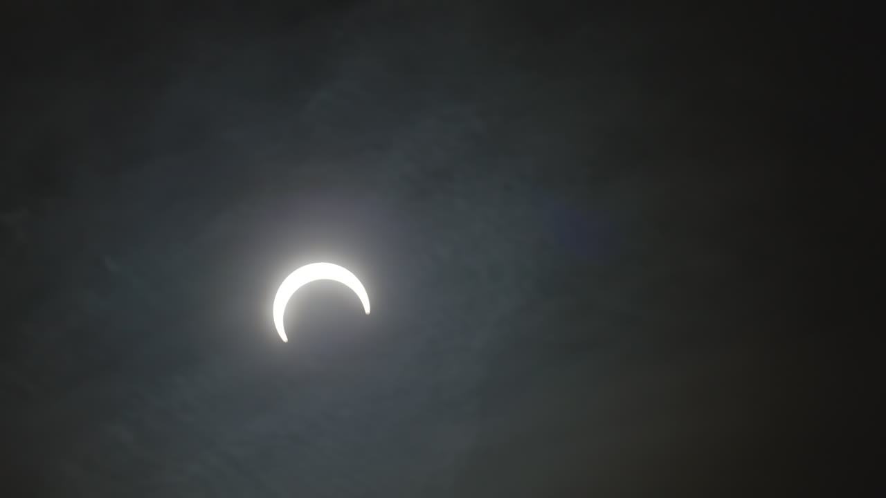 lapso de tiempo de la luna en el cielo con nubes durante el eclipse solar anular