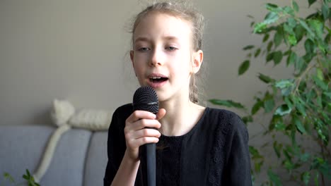 cute little girl singing karaoke at home.