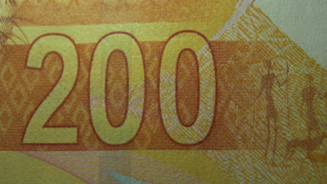 this is the macro view of a normal paper banknote- money- currency of 200 south african rand