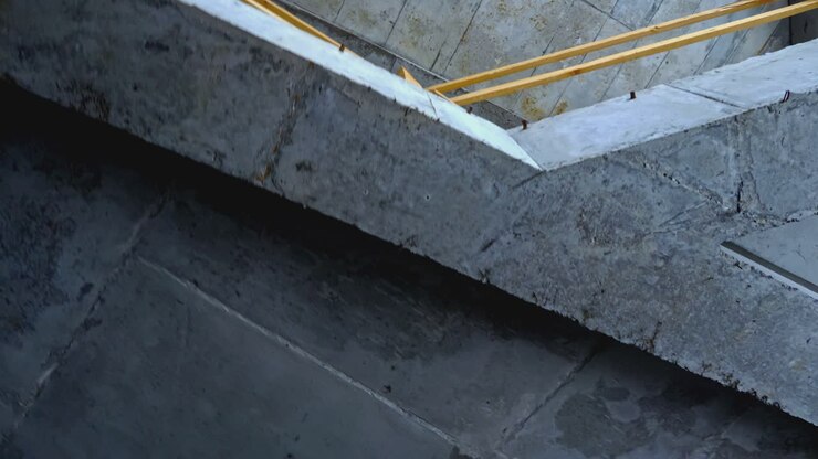 Construction site interior view showing wooden and concrete beams