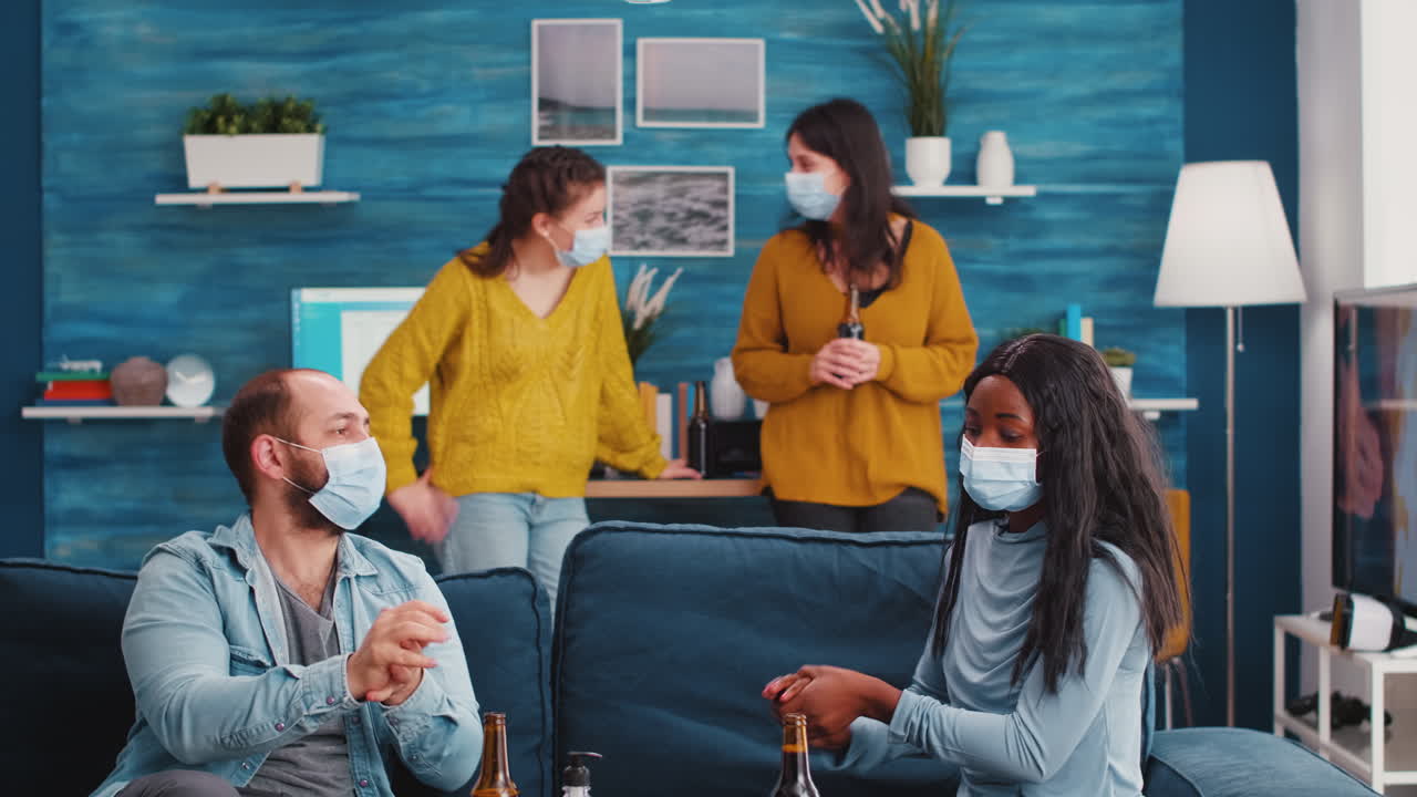 Group of diverse friends using hand sanitizer gel and protective masks
