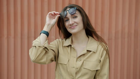 woman in a tan jumpsuit and sunglasses
