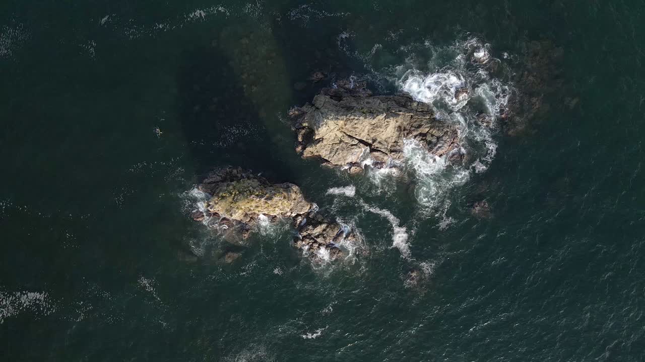 vista aérea de las olas rompiendo en dos grandes rocas en la playa de manuel antonio en quepos, costa rica, vista panorámica de arriba hacia abajo