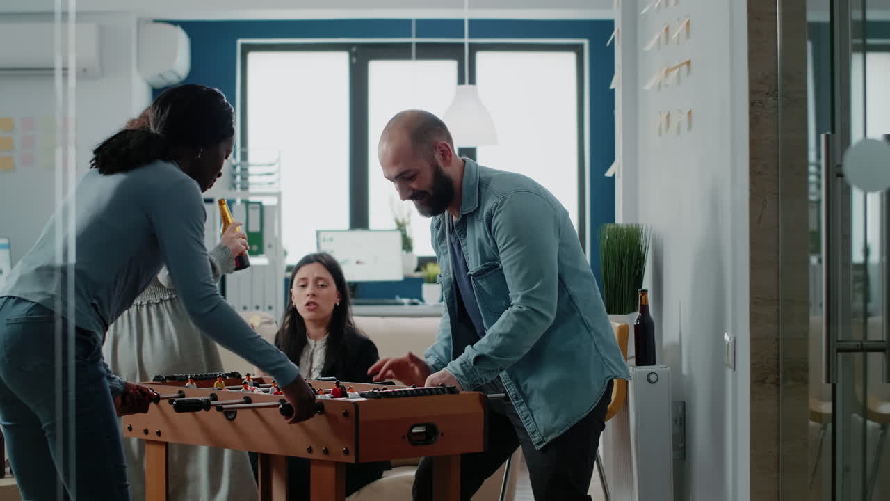 Multi ethnic colleagues enjoying play at foosball table