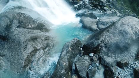 Vista-De-Cerca-De-Una-Cascada-Escénica-Con-La-Brisa-Del-Agua-Salpicando-En-Las-Rocas,-Aún-Tiro-De-Fondo-De-La-Naturaleza