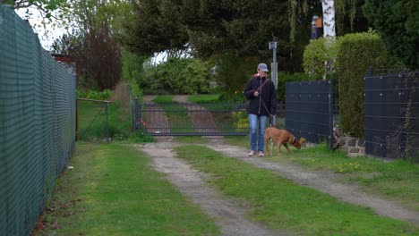 dog walking with his owner on a sidewalk