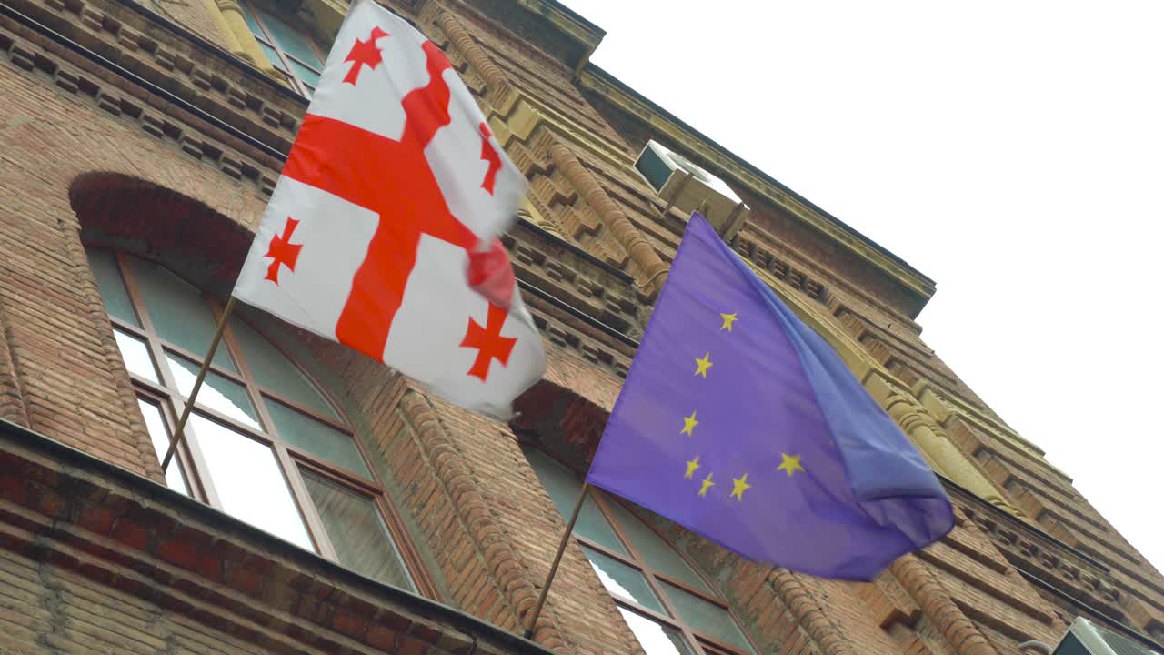 유럽과 조지아의 발은 은 날 건물과 하늘의 배경에 바람에 발달하고 있습니다.