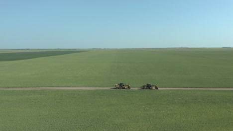 niveladoras de caminos que nivelan el camino de tierra en vastas praderas verdes de las zonas rurales de canadá