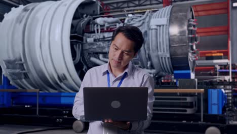engineer reviewing data on a laptop in an industrial facility