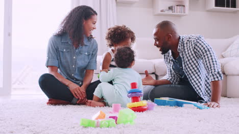 Una-Joven-Familia-Negra-Jugando-En-El-Suelo-De-La-Sala-De-Estar