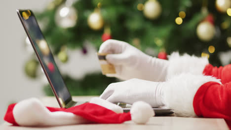 santa claus usando una computadora portátil sobre el árbol de navidad y las luces
