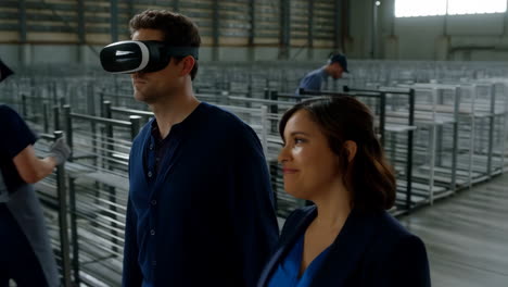 man in vr headset with woman in warehouse