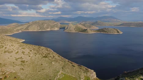 vista panorámica del lago yliki en grecia con montañas alrededor y nubes