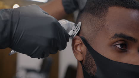 man getting a haircut at barber shop during covid-19 pandemic