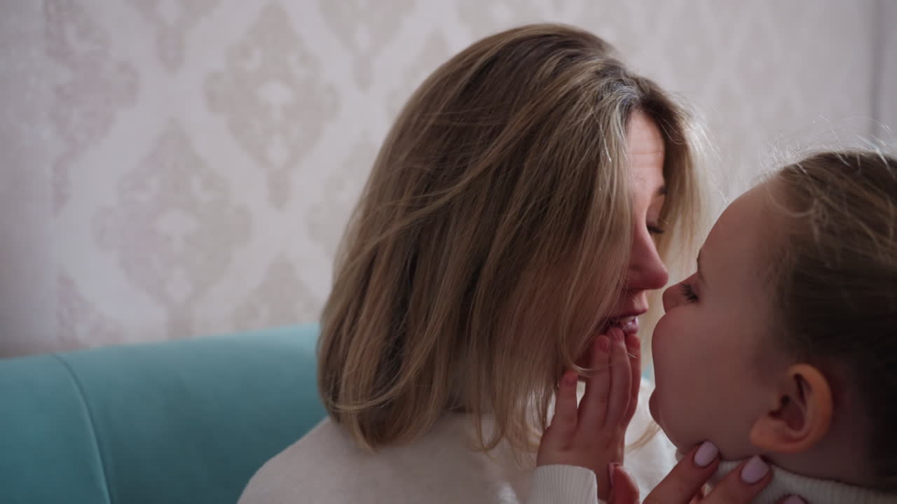 Young mother relaxing on sofa in cozy home environment wearing white turtleneck, eyes closed while child hand gently touches her hair, moment of tenderness, family comfort,, domestic lifestyle