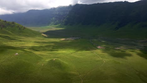 the dancing shadows of passing clouds, creating a captivating symphony of tranquility and enchanting allure of a valley, the famous valley in mount bromo area, the iconic active volcano in indonesia