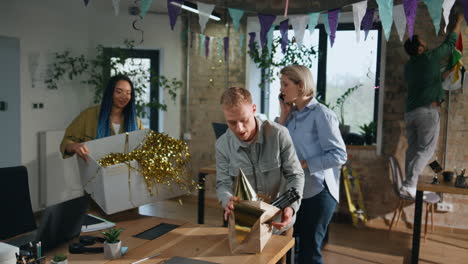 office people preparing birthday party in coworking room. couple unpacking boxes