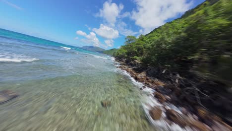 Paraíso-Caribeño,-Vuelo-FPV-A-Lo-Largo-De-La-Costa-Rocosa-De-La-Jungla-En-Un-Día-Soleado