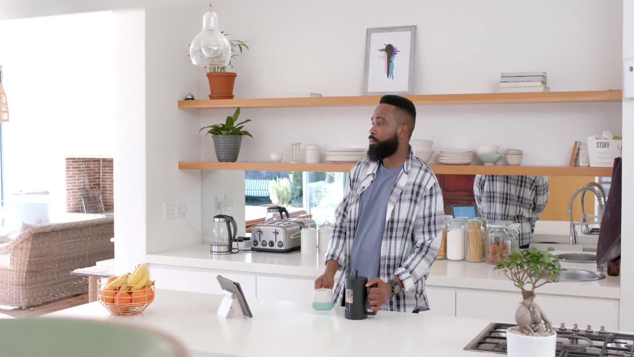 hombre afroamericano bebiendo café en la cocina, cámara lenta