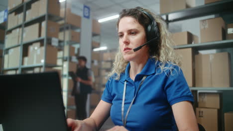 trabajador de almacén en portátil con auriculares