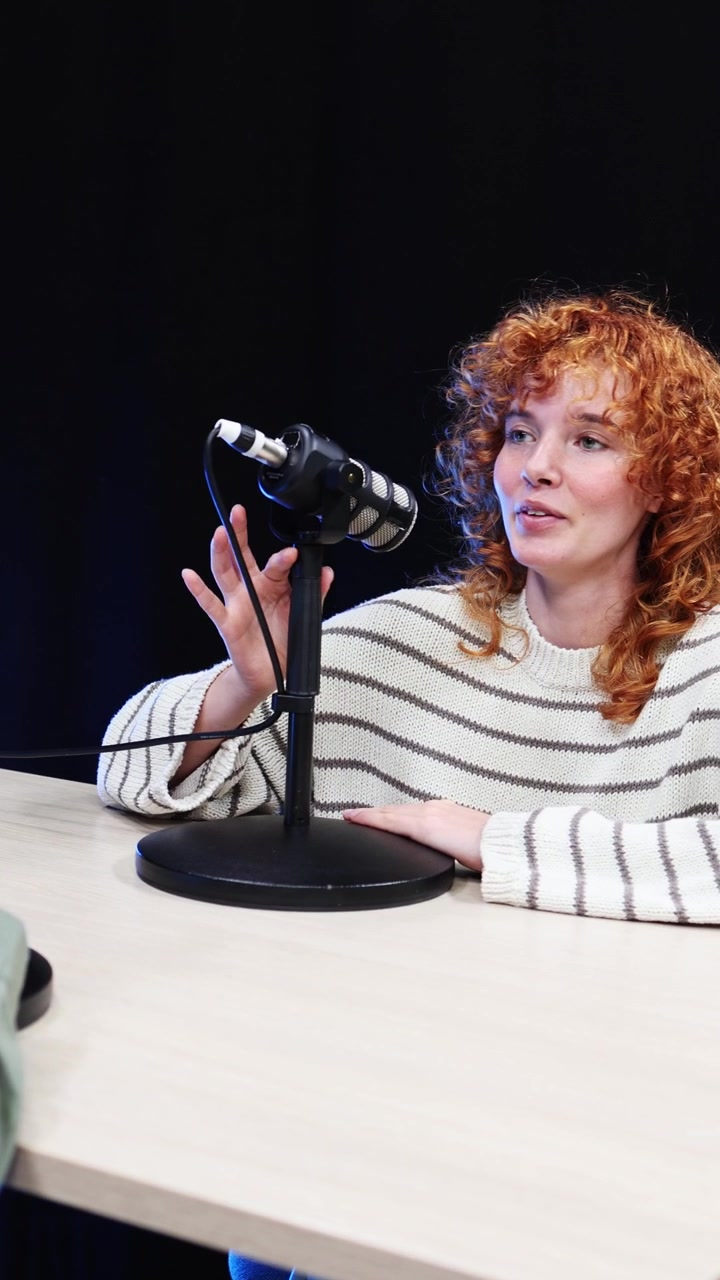 Happy Young Woman with Red Curly Hair Recording a Podcast
