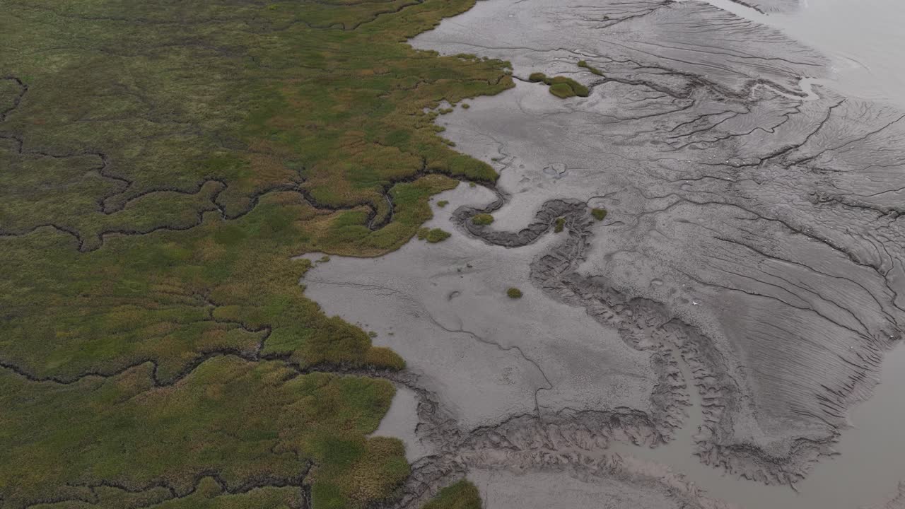 Aerial drone footage of the Portbury marshlands and coastline nature reserve, showcasing tidal wetlands, cloudy weather atmosphere, and tranquil coastal habitat along England’s western shores