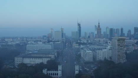 Elevated-footage-of-long-straight-street-leading-through-city.-Cityscape-before-sunrise.-Warsaw,-Poland