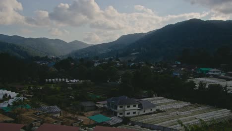 rural village in a lush mountain valley with agricultural greenhouses