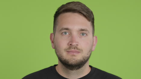 Man-Removes-Protective-KN95-Face-Mask-While-Looking-Into-Camera-on-Green-Screen-Chroma-Key-Close-Up