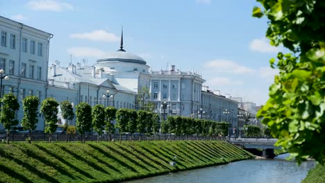 european city street scene with canal and trees