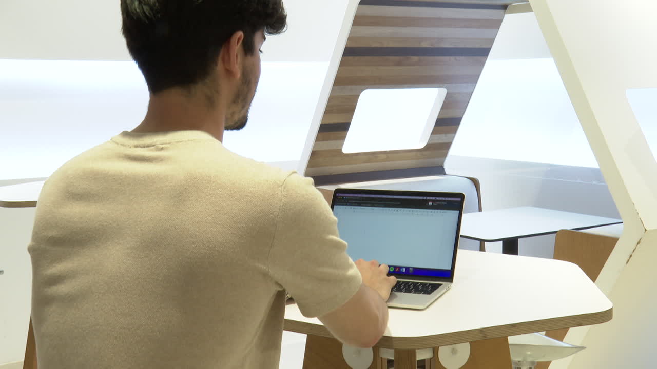 Person Working on Laptop in Modern Workspace