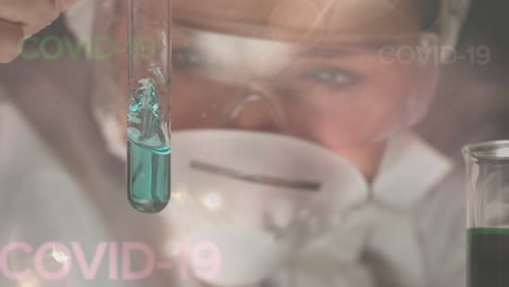 healthcare worker looking at test tube during coronavirus covid19 pandemic