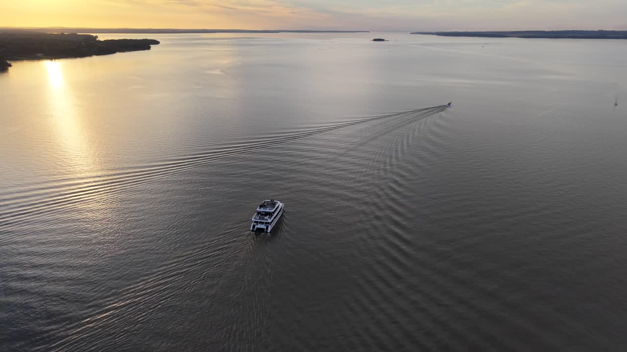 Una splendida ripresa aerea con drone di un catamarano di lusso che naviga su acque calme durante l'ora d'oro