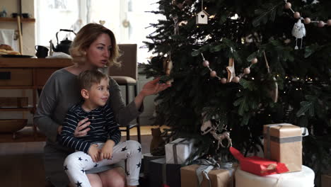 mother and son decorate the christmas tree together 1