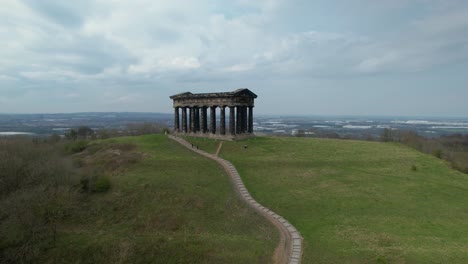 aerial cinematic rotating shot of penshaw monument with grass field and stairs in the foreground