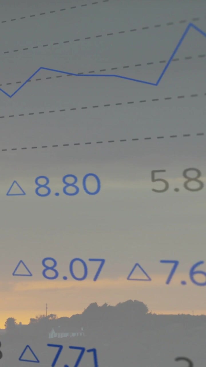 Vertical video: Incoming data updating market chart overlaying sunset, blue trend line rising