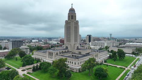 nebraska state capitol in lincoln, surrounded by cityscape, green lawns, and overcast skies