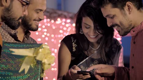 good looking office colleagues using an application or shopping online on a cell phone during diwali