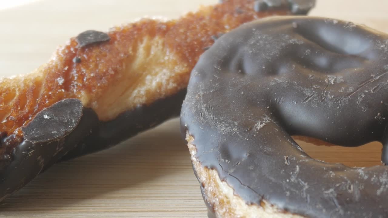 Golden palmeras pastry coated in chocolate, close-up of crunchy texture