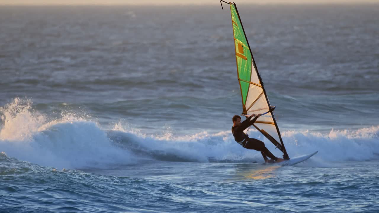 surfista masculino haciendo windsurf en la playa 4k