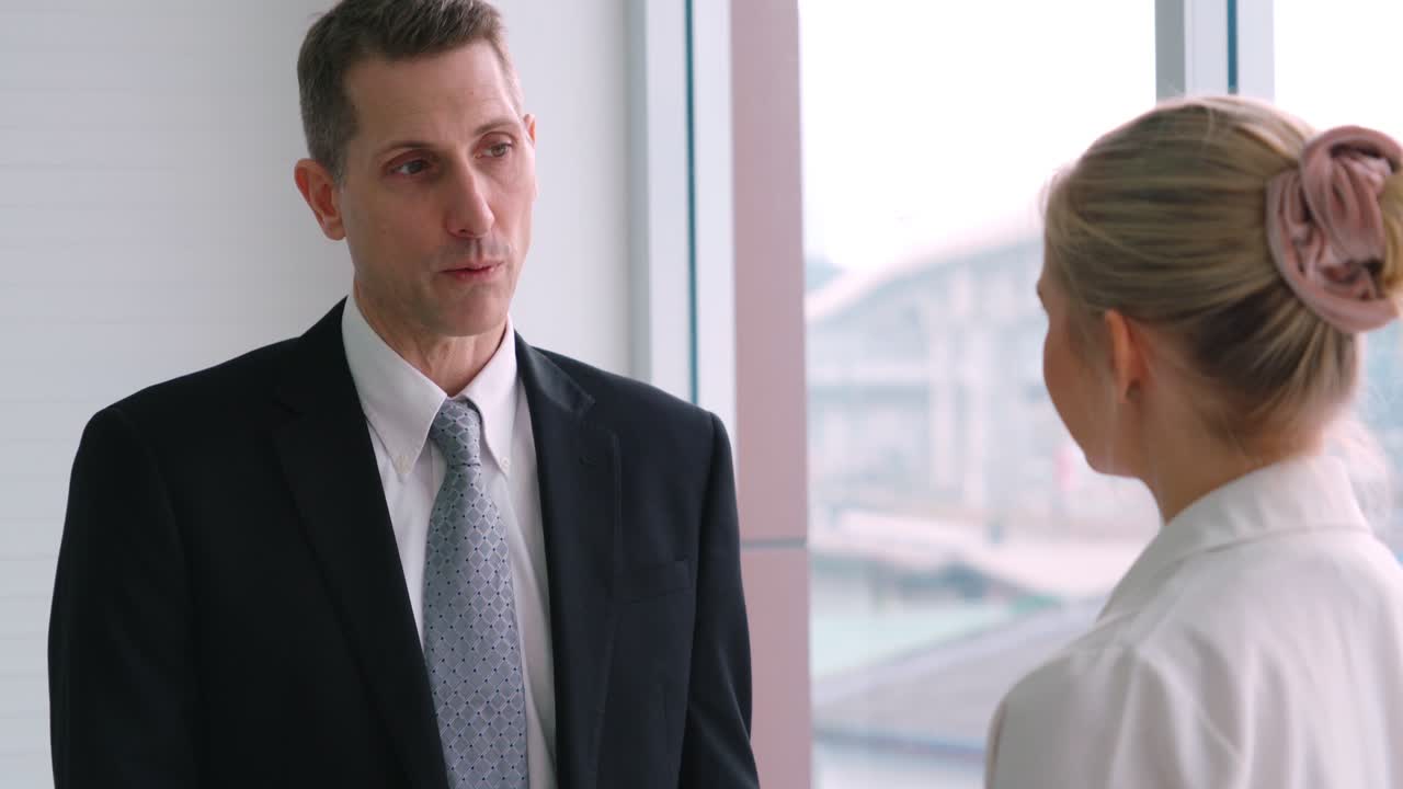 Two business people talk project strategy at office