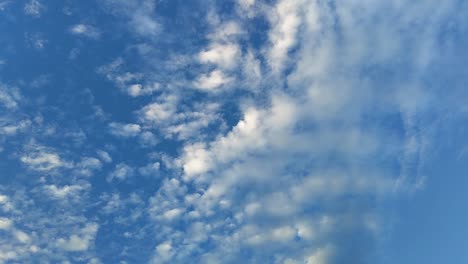 capture the serene beauty of white clouds drifting through a vibrant blue sky in this captivating trending footage