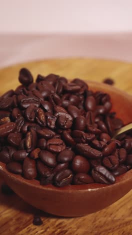 Coffee-beans-in-bowl-being-scooped-by-golden-spoon-in-Slow-Motion