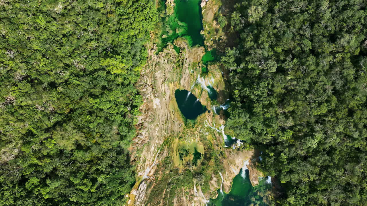Vista aerea da drone della cascata di Tamul che scende a cascata da scogliere verdi in una piscina turchese sottostante